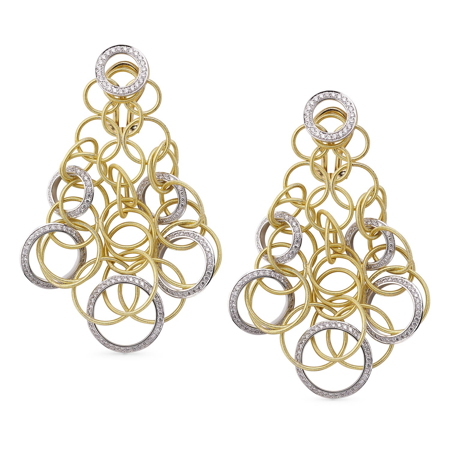 A woman on a rocky beach in a dark brown shearling lined barn jacket over a yellow and black printed dress.